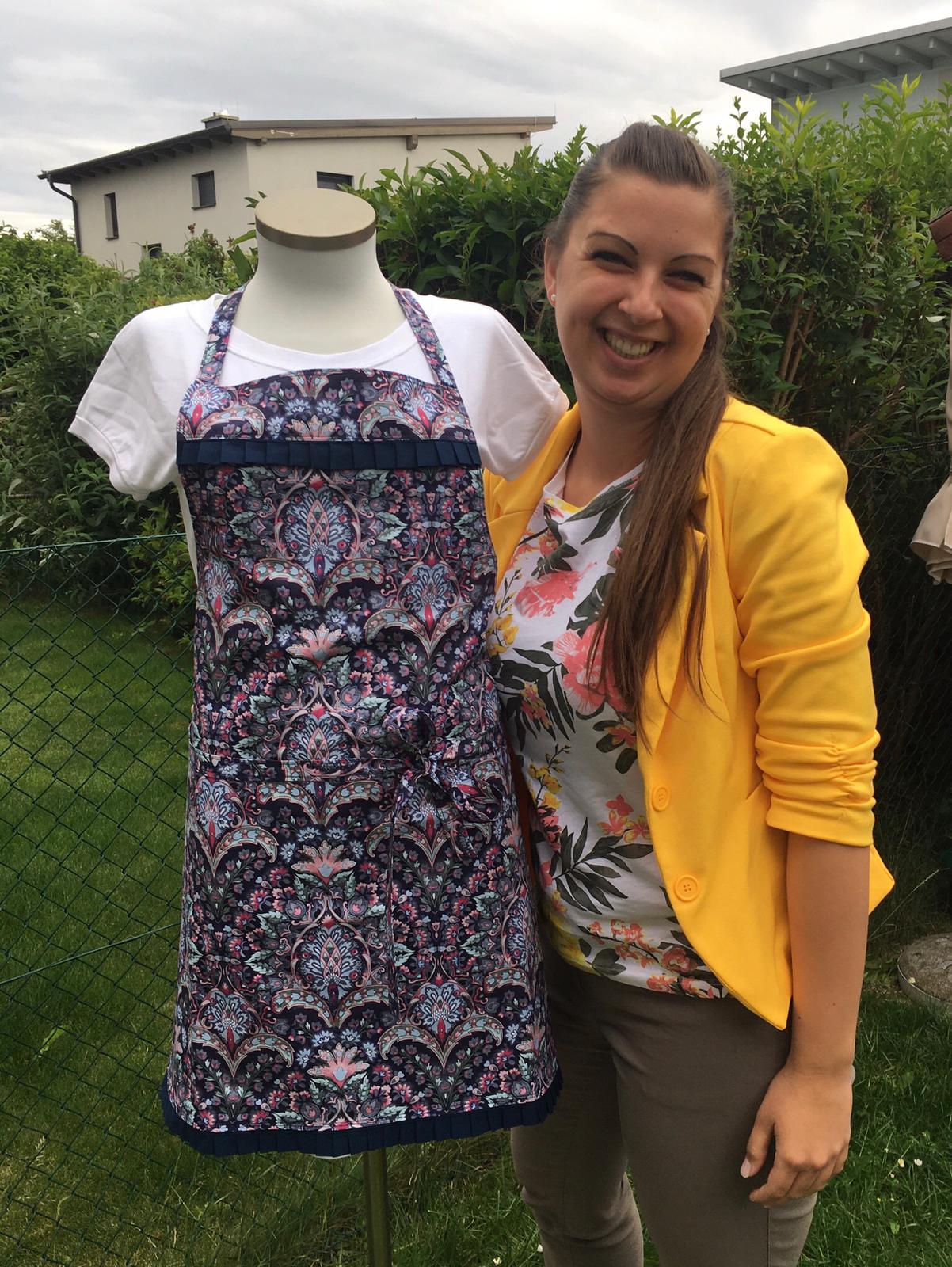 Andrea Wieshofer in gelbem Blazer neben einer Schneiderpuppe mit geblümter Schürze