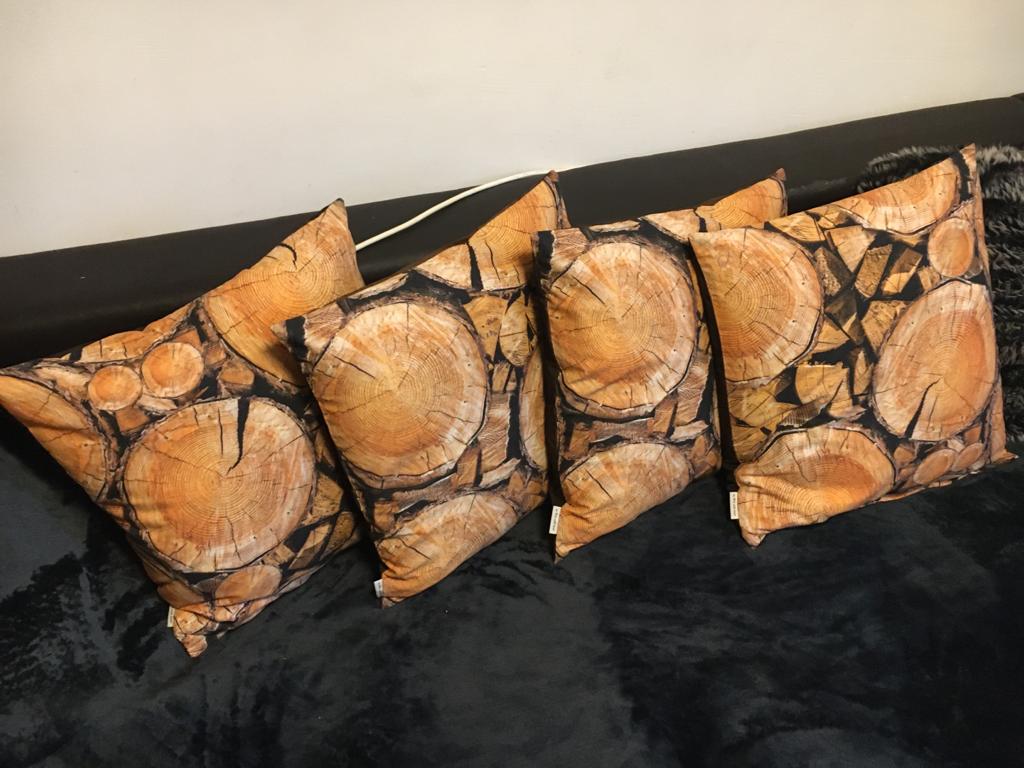 Vier quadratische Kissen mit Holzscheiben-Print