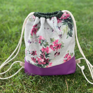 Turnbeutel mit Blumenmuster und lila Boden auf der Wiese