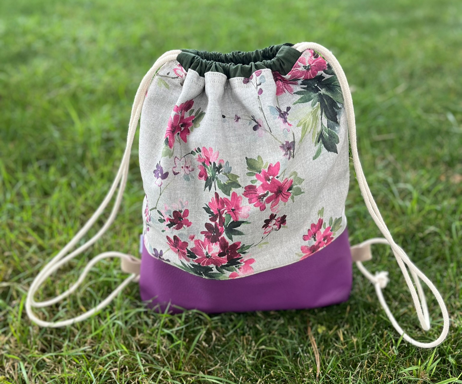 Turnbeutel mit Blumenmuster und lila Boden auf der Wiese